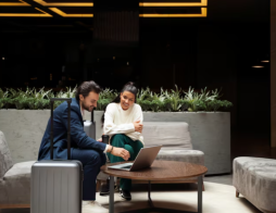 Homem e mulher sentados em sala vip de aeroporto.