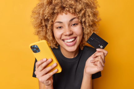 Jovem segurando cartão XP Visa Infinite próximo ao rosto.