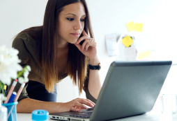 Jovem mulher fazendo a declaração anual do MEI via computador.