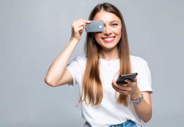 Mulher segurando cartão Inter Gold próximo ao rosto e sorrindo.