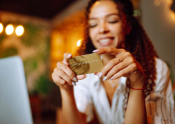 Jovem segurando o cartão Inter Gold.