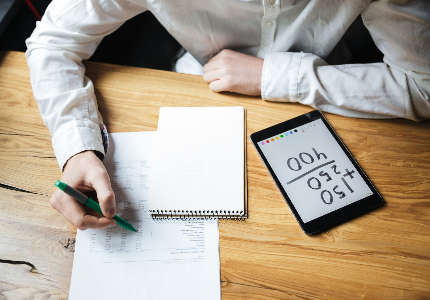 Persona comparando tasas de interés y CAT de un préstamo personal en México usando calculadora y notas financieras