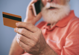 Homem segurando cartão de crédito enquanto fala ao telefone