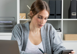 Pessoa calculando juros do cartão de crédito com calculadora
