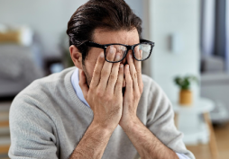 Homem preocupado cobrindo o rosto após problema financeiro